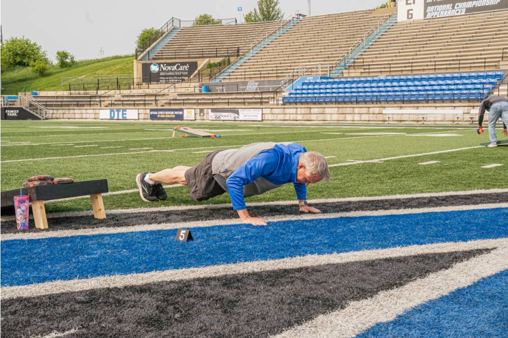 Scott Grissom doing pushes on the football field in Lubbers Stadium